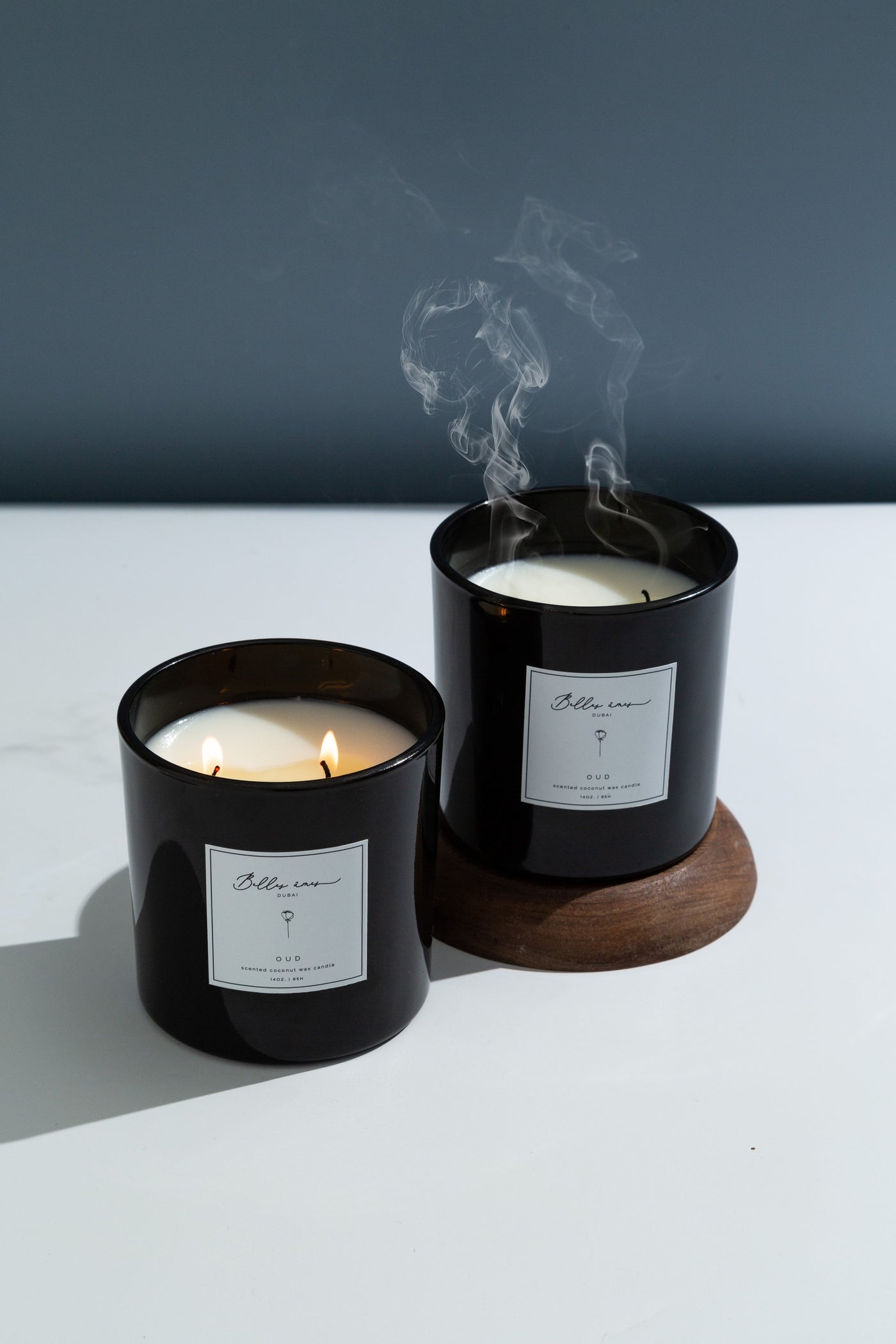 Oud candle in black vessel with a petrol blue background